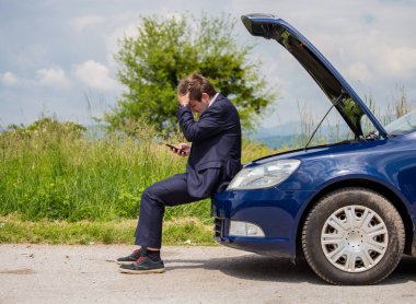 Kırık bir araba yolda sürücü kafasını, açık bir başlık, bir araba başarısızlık tutuyor