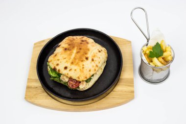 tavuk parçaları, yeşil salata ve domates, patates kızartması ve maydanoz ile süslenmiş sandviçle bırakır, beyaz arka plan