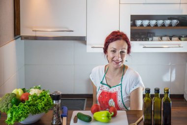 Mutfakta genç bir kız, yüzüne gülümse, öğle yemeği pişir, çeşitli sebzeler hazırla, marul, brokoli, mutfak, kız mutfakta, Cassia sebzeleri.