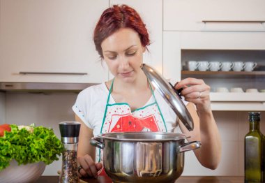 Mutfakta genç bir kız, yüzüne gülümse, öğle yemeği pişir, çeşitli sebzeler hazırla, marul, brokoli, mutfak, kız mutfakta, Cassia sebzeleri.