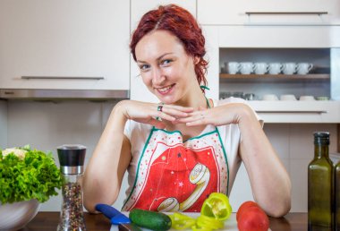 Mutfakta genç bir kız, yüzüne gülümse, öğle yemeği pişir, çeşitli sebzeler hazırla, marul, brokoli, mutfak, kız mutfakta, Cassia sebzeleri.