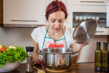 Mutfakta genç bir kız, yüzüne gülümse, öğle yemeği pişir, çeşitli sebzeler hazırla, marul, brokoli, mutfak, kız mutfakta, Cassia sebzeleri.
