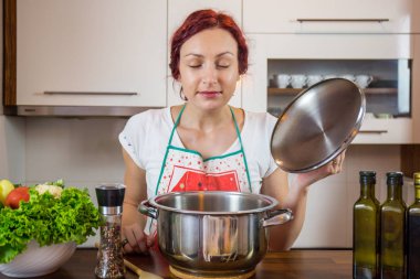 Mutfakta genç bir kız, yüzüne gülümse, öğle yemeği pişir, çeşitli sebzeler hazırla, marul, brokoli, mutfak, kız mutfakta, Cassia sebzeleri.