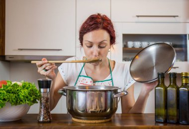 Mutfakta genç bir kız, yüzüne gülümse, öğle yemeği pişir, çeşitli sebzeler hazırla, marul, brokoli, mutfak, kız mutfakta, Cassia sebzeleri.