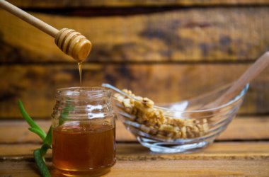 Ahşap zemin üzerinde ceviz ve bal olan kompozisyon