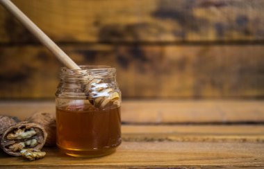 Ahşap zemin üzerinde ceviz ve bal olan kompozisyon