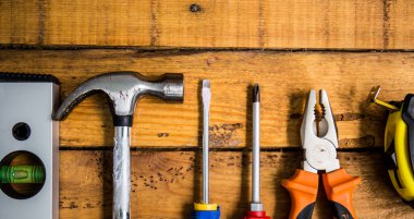 Ahşap bir arka plan üzerinde çalışmak için araçlar, metin için yerler. Çekiç, kerpeten ve diğer aletler var.