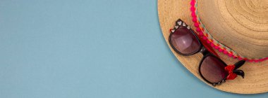 Mavi arka planda plaj aksesuarları, plaj terlikleri, şapka, gözlükler. Boşluğu kopyala, metin alanını. Denizde tatiller