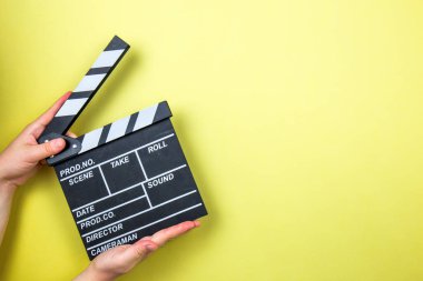 Sarı arka planda film alkışı, sinema konsepti