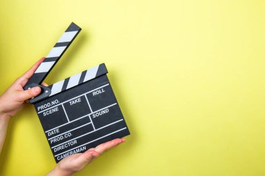 Movie clapper on yellow background, cinema concept clipart