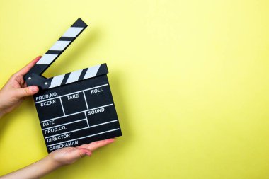 Sarı arka planda film alkışı, sinema konsepti