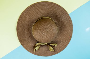 Sarı ve mavi arka planda çizgili bir şapkadan yapılmış yaratıcı bir görünüm. Kopyalama alanı olan en küçük yaz kavramı.