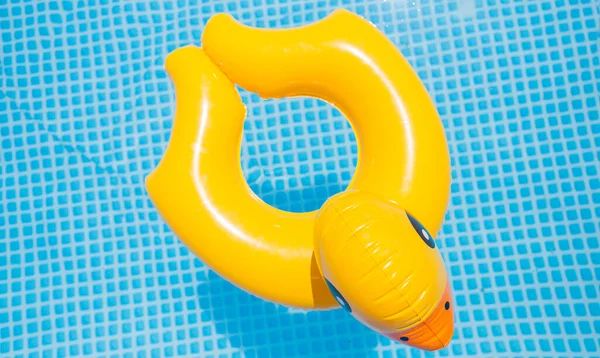 子供のためのプールで気楽で安全な夏は喜んで救命ゴム黄色のアヒルとターコイズブルーの水に浮かんで楽しむことができます — ストック写真
