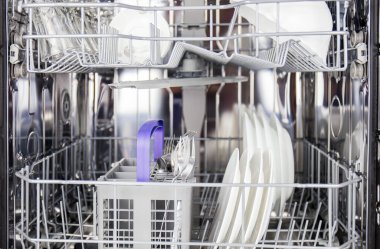 Tabak kapları ve cam eşyalar, modern mutfakta modern bulaşık makinesi kullanılarak her gün evlerde temizleniyor. Resmi kapat @ info