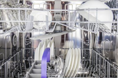 Tabak kapları ve cam eşyalar, modern mutfakta modern bulaşık makinesi kullanılarak her gün evlerde temizleniyor. Resmi kapat @ info