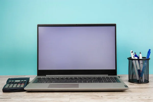 Laptop computer with a white screen on the desktop, blue background. Business and finance