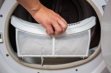 Kurutucu filtre, kirli ve temizlenmesi gerekiyor. Çamaşır tozu bir yerde toplanmış.