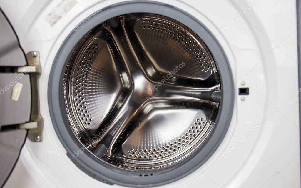 Washing machine, close-up image, drum from the machine is sifting, cleanliness of the machine and clothes