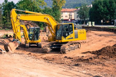 Çalışan makineler, daha iyi ve daha hızlı ulaşım sayesinde yolların yeniden inşası. Eski boruların kazılması ve yeni bir su şebekesi kurulumu