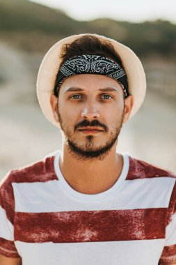 Şapka ve çizgili tişört genç sakallı adam portresi