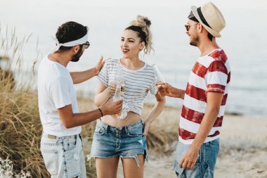 Konuşmak ve bira içmek sahilde mutlu gençlerin Grup