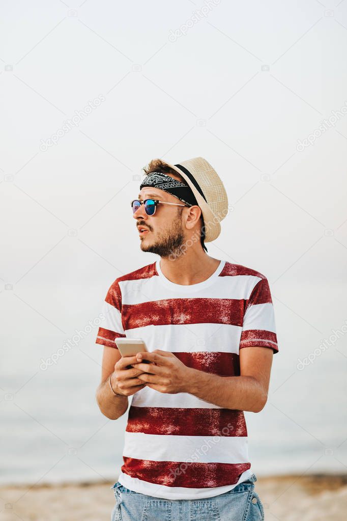 Young man at the beach using mobile phone