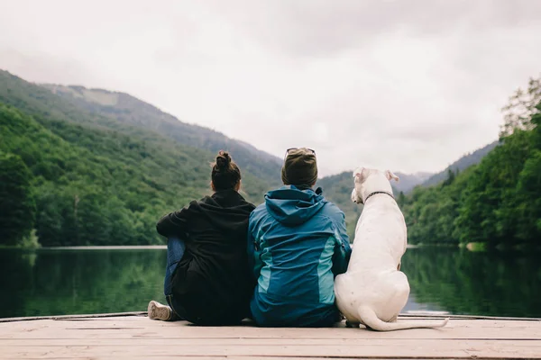 Vista Trasera Pareja Con Pitbull Relajándose Muelle Sobre Fondo Las — Foto de Stock