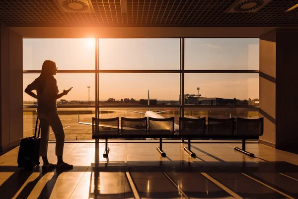 Smartphone kullanarak kalkış, uçuş için bekleyen kadın