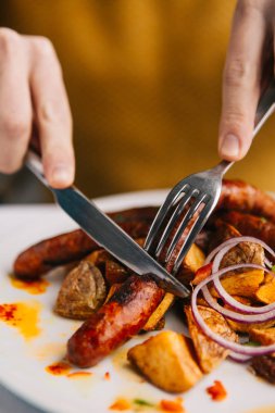 bıçak ile çatal tutan kişi kırpılmış shot ve lezzetli sosis yeme