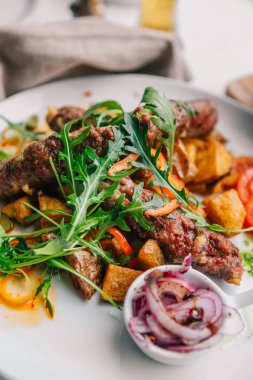 Lezzetli yemek yakın. Patates ve salata ile et. Cevapi