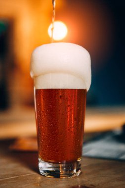 köpükle cam içinde dökülen soğuk biranın yakın çekim görünümü