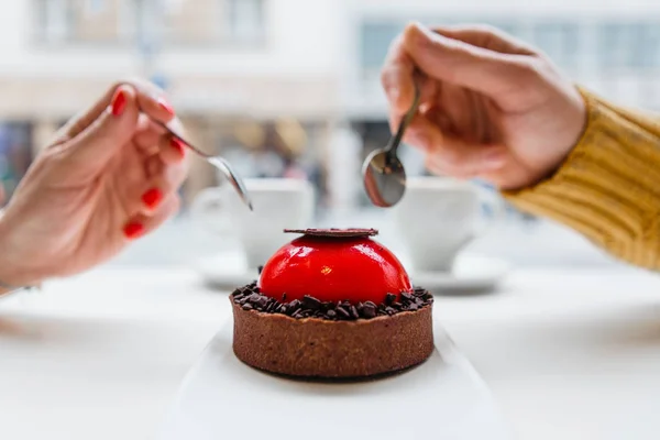 cropped shot of couple holding spoons and eating delicious cake together