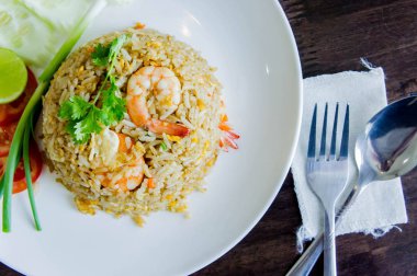 Karidesli Tay gıda tarzı ahşap masa üzerinde beyaz bir tabak kızarmış pilav