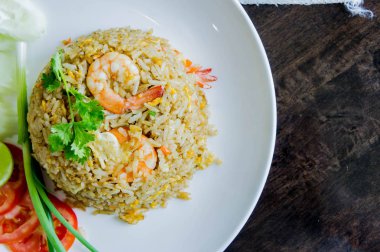 Karidesli Tay gıda tarzı ahşap masa üzerinde beyaz bir tabak kızarmış pilav