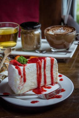 ahşap masa kafede, tatlı tasy pasta çilekli krep pasta