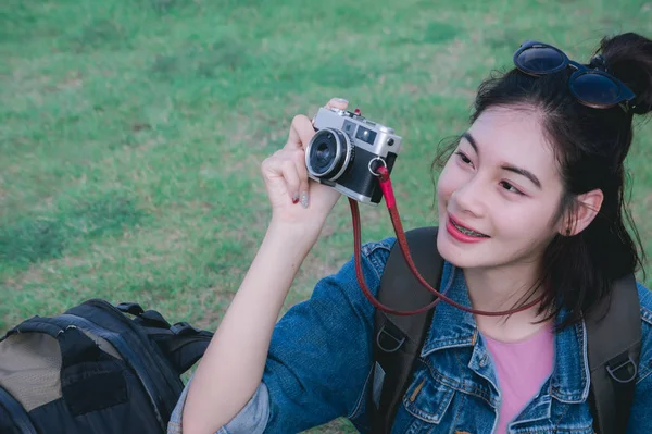 旅行女孩坐在拍照和微笑看周围的自然 — 图库照片