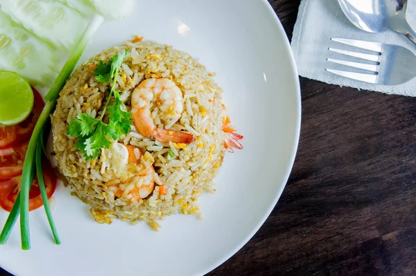 Arroz frito com camarão em um prato branco na mesa de madeira em tailandês foo — Fotografia de Stock