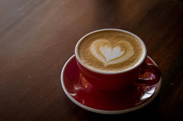 O amor de café de xícara vermelho, café escuro na mesa escura de madeira — Fotografia de Stock