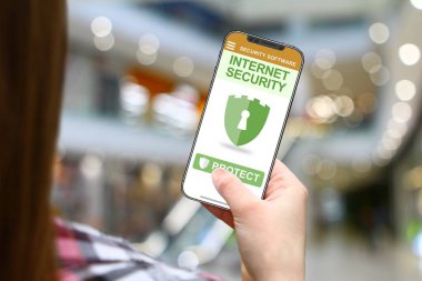 Internet güvenlik kavramı, bulanık alışveriş arka plan üzerinde çerçevesiz telefon ile kız