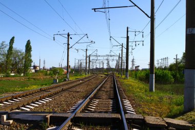 Kırlarda yaz aylarında demiryolu yolda bir sürü elektrik direkleri üzerine iki tarafın