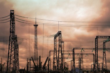 Yüksek gerilim elektrik santrali - elektrik direkleri ve sarı bulutlu gökyüzü arka plan üzerinde satırları