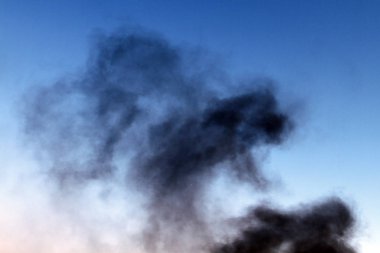 mavi gökyüzü arka plan üzerinde siyah duman ayağı.