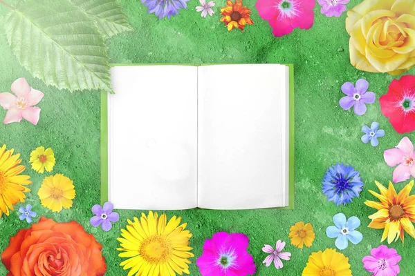 Beautiful flower frame with notepad in center on green sandy ground background.