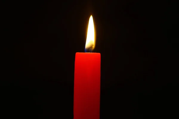 站立蜡照明红色蜡烛以生动的火焰在重的黑背景 — 图库照片