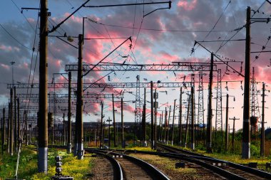 Demiryolu geçidi İstasyonu ile pembe gökyüzü arka plan üzerinde elektrik direkleri