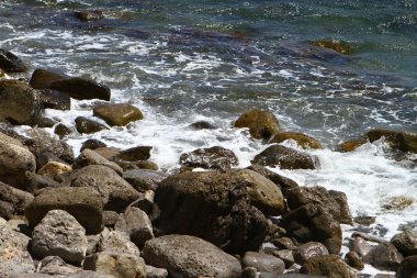 doğal peyzaj fotoğraf bir yaz gününde büyük taşlarla güzel taşlı parlak mavi deniz plaj