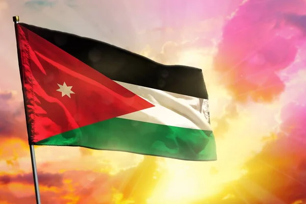 Fluttering Jordan flag on beautiful colorful sunset or sunrise background. Jordan success or happiness concept.