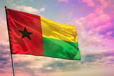 Gine-Bissau bayrak renkli bulutlu gökyüzü arka planda çırpınan. Gine-Bissau prospering kavramı.