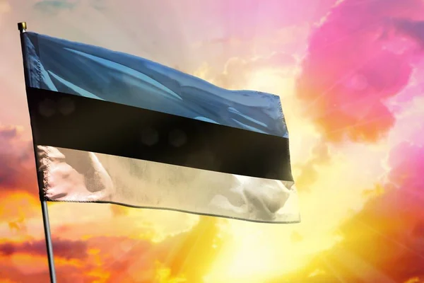 美しいカラフルな夕日や日の出背景にエストニアの旗を舞います エストニアの成功と幸福の概念 — ストック写真