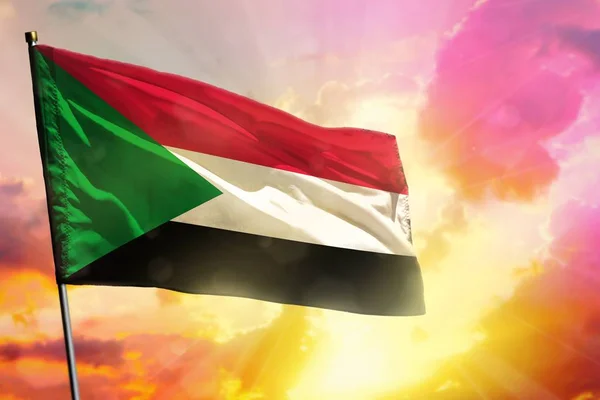 Fluttering Sudan flag on beautiful colorful sunset or sunrise background. Sudan success and happiness concept.